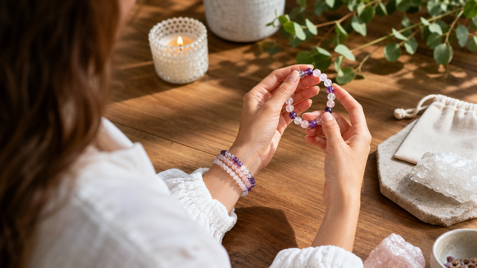 Woman comparing purple quartz bracelets beside crystal specimens